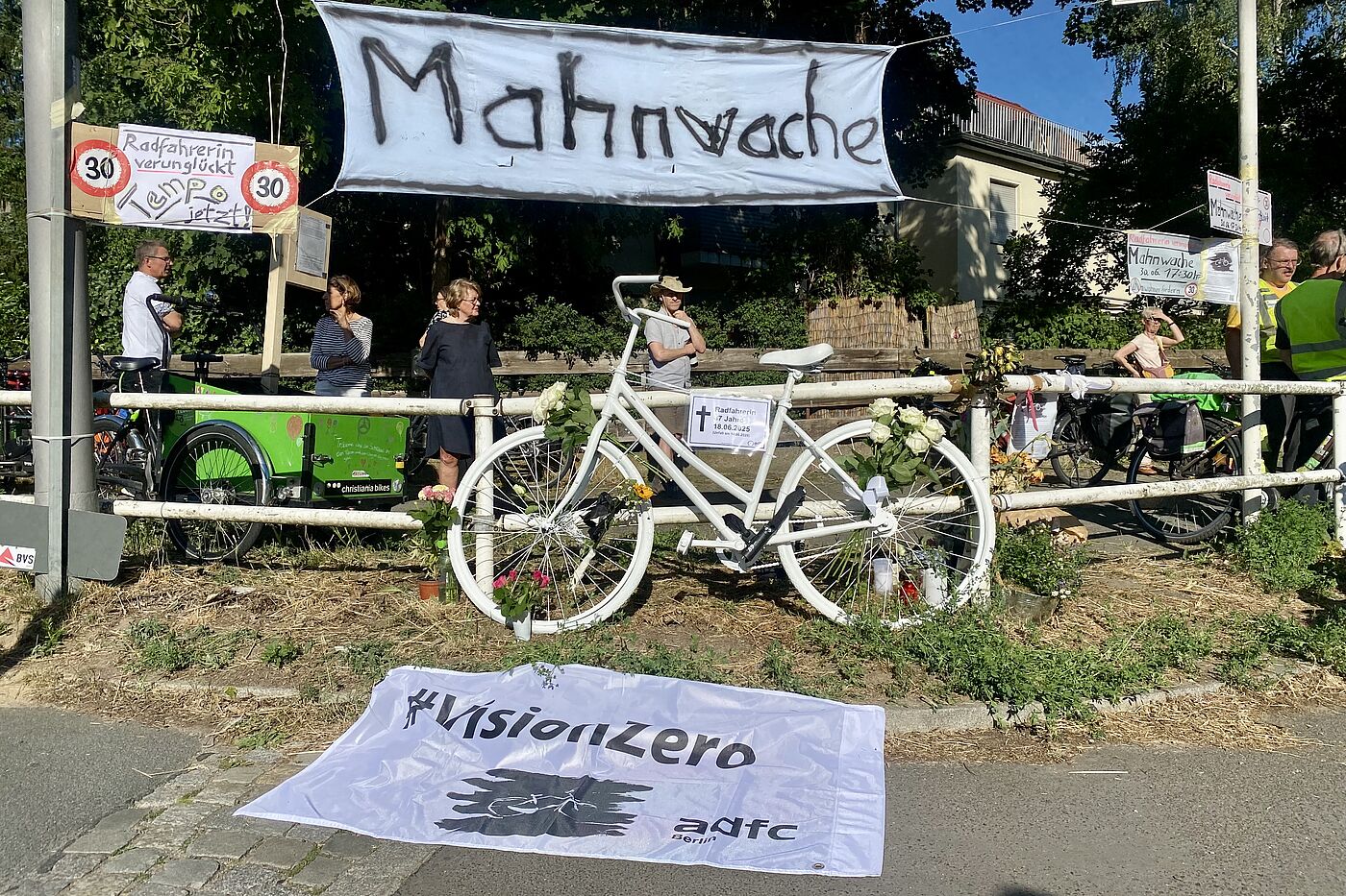 Mahnwache am 30.06.2025 auf der Clayallee in Berlin Zehlendorf Eine weiße VisionZero Fahne des ADFC Berlin kennzeichnet die Stelle, an der eine Radfahrerin auf der Berliner Clayallee angefahren wurde.