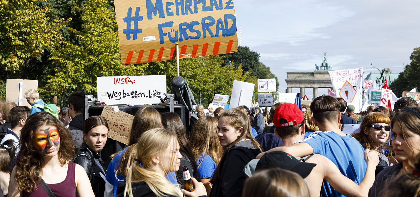Aktiv im Frauen*Netzwerk Teilnehmende halten bei einer Demo ein Schild hoch.