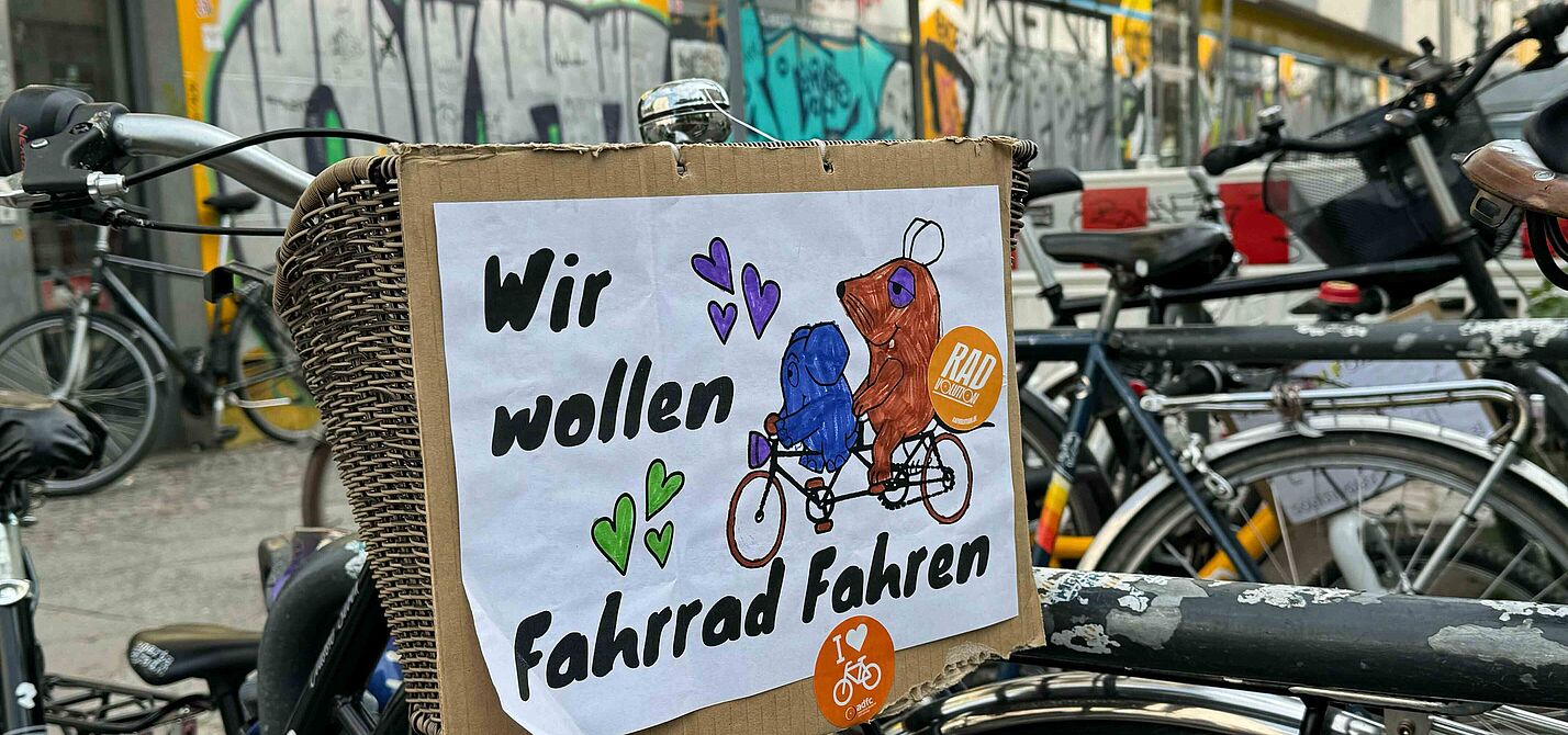 Kidical Mass 2024 Selbstgemaltes Schild an Fahrrad mit der Maus und Elefanten auf dem steht: Wir wollen Fahrrad fahren