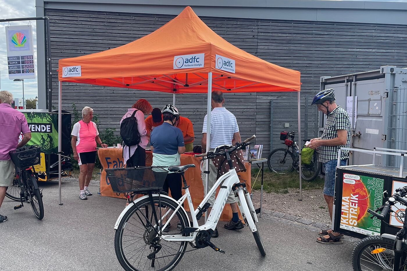 Codiermöglichkeit an der Radtankstelle orangener Pavillon mit Personen und Fahrrad