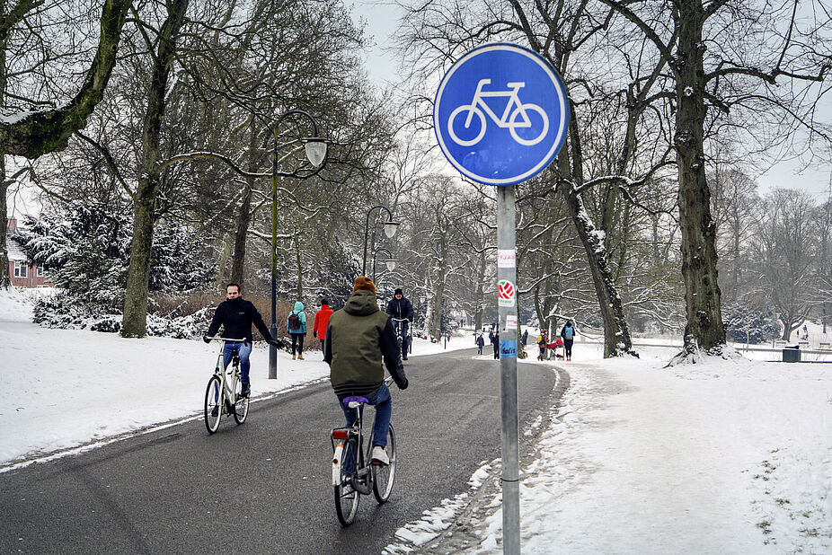 Winterlicher Fahrradweg in Groningen Radfahrer auf geräumten Radweg in Groningen