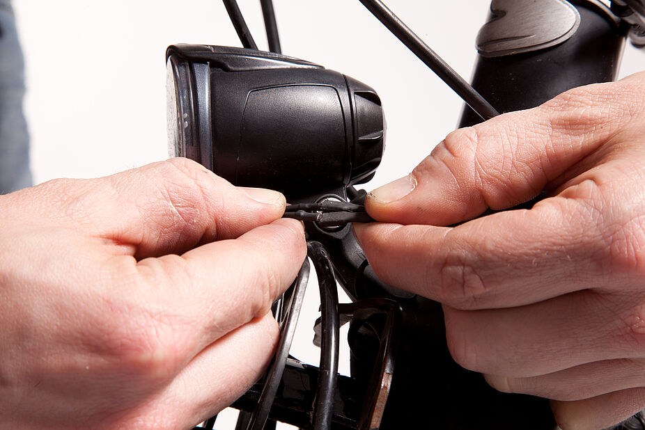 Fahrradpflege: Lichtkontrolle Kabelkontrolle am Scheinwerfer