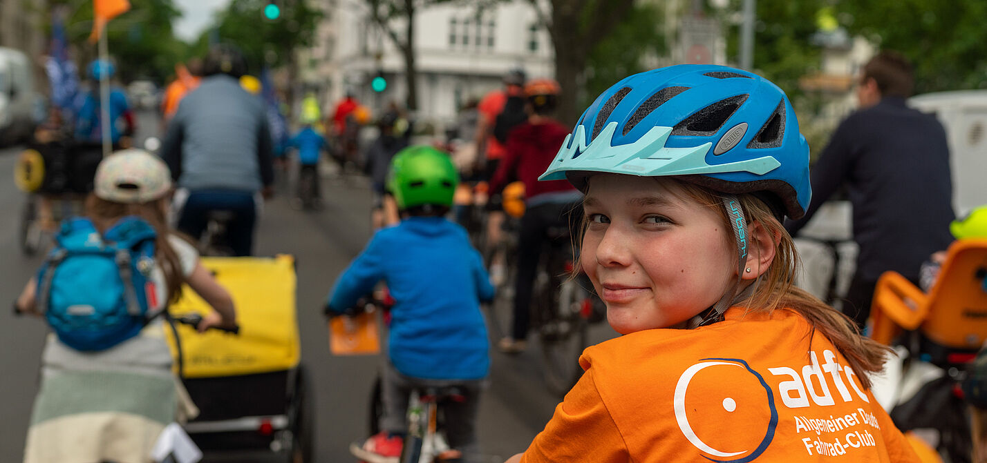 Kind auf Fahrrad schaut in die Kamera