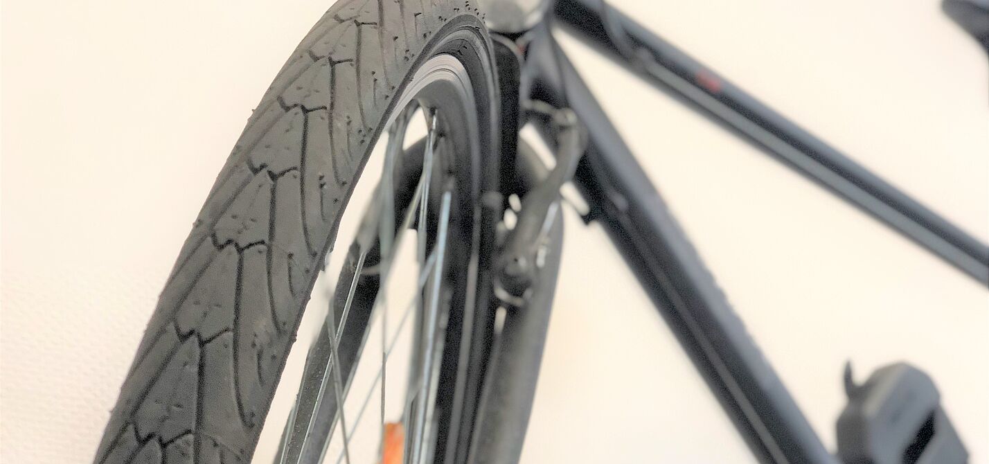 Reifen Portrait Aufnahme eines Reifens frontal, Fahrrad verschwommen im Hintergrund.